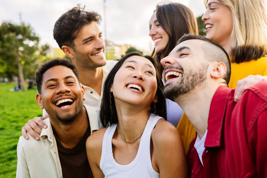 Diverse group of friends laughing together outdoors